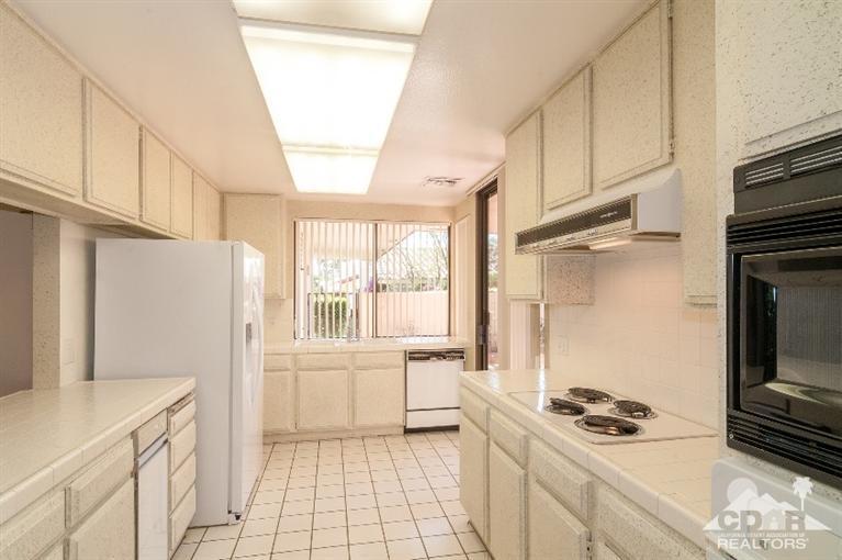 11 Wake Forest Court Rancho Mirage, CA 92270 - Photo 16 of 25 a kitchen with a stove a refrigerator and a white cabinets