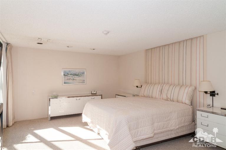 11 Wake Forest Court Rancho Mirage, CA 92270 - Photo 23 of 25 a bedroom with a bed and a lamp