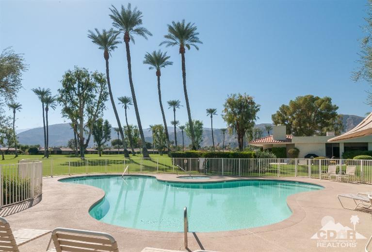 11 Wake Forest Court Rancho Mirage, CA 92270 - Photo 6 of 25 a view of a swimming pool with a lawn chairs under an umbrella