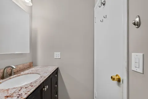 a bathroom with a granite countertop sink and a mirror