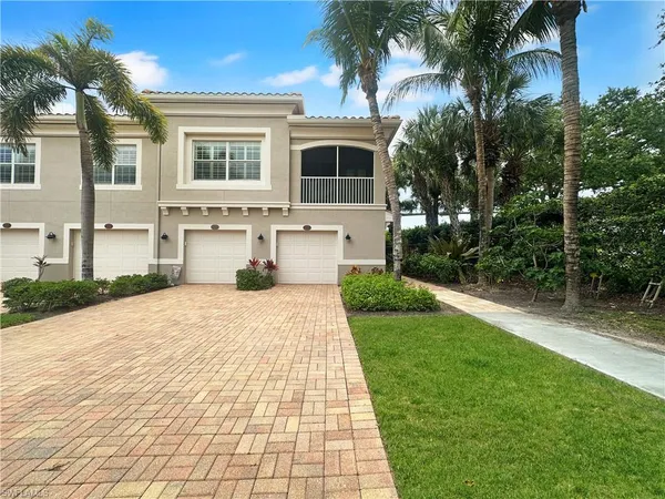 a front view of a house with a yard and potted plants