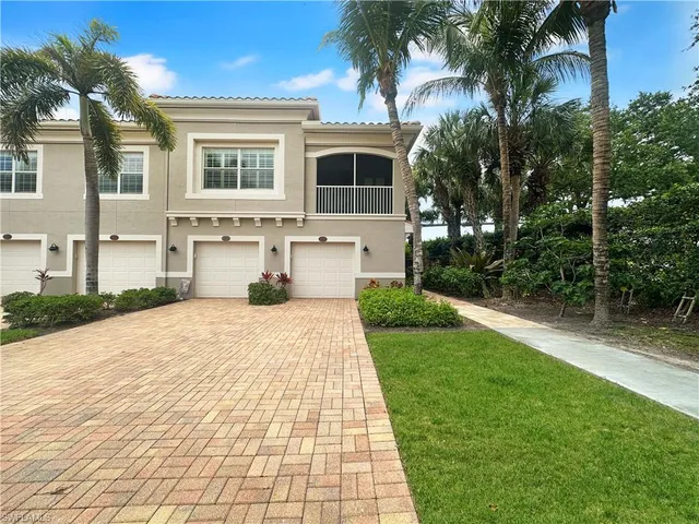 a front view of a house with a yard and potted plants