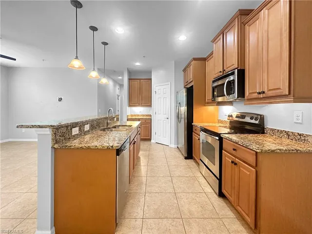 a kitchen with stainless steel appliances granite countertop a refrigerator a oven a sink a counter top space and cabinets