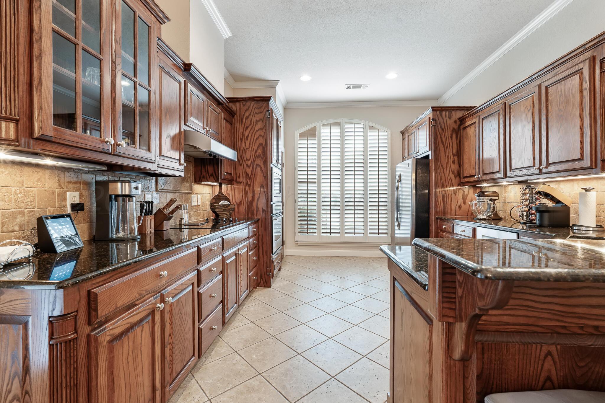 5008 Wesley Road Amarillo, TX 79119 - Photo 13 of 47 a kitchen with stainless steel appliances granite countertop a sink and cabinets