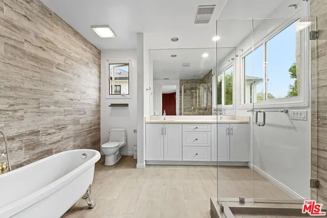 a bathroom with a granite countertop sink mirror bathtub and toilet