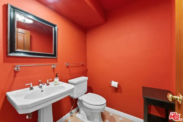 a bathroom with a toilet sink and mirror