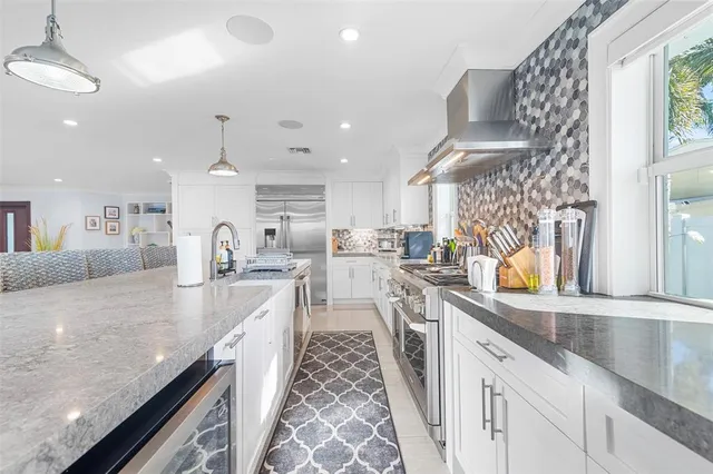 a large kitchen with stainless steel appliances granite countertop a lot of counter space and wooden floors