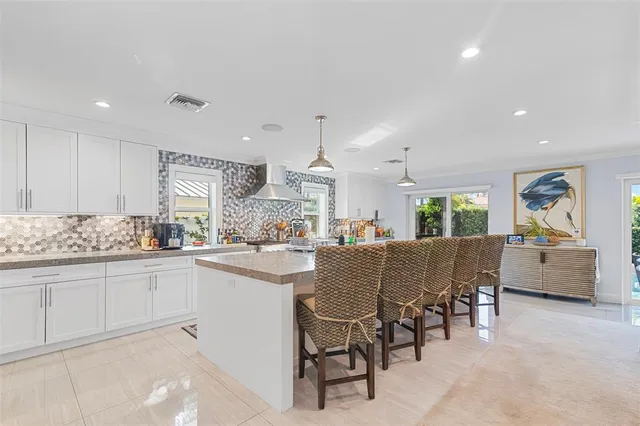 a dining hall with stainless steel appliances kitchen island granite countertop furniture and a kitchen view
