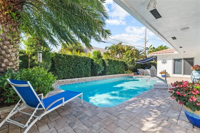 a view of a chair and tables in the patio with a garden