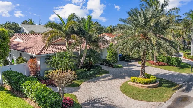 a front view of a house with a yard and a garden