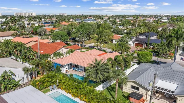 an aerial view of residential houses with outdoor space and trees