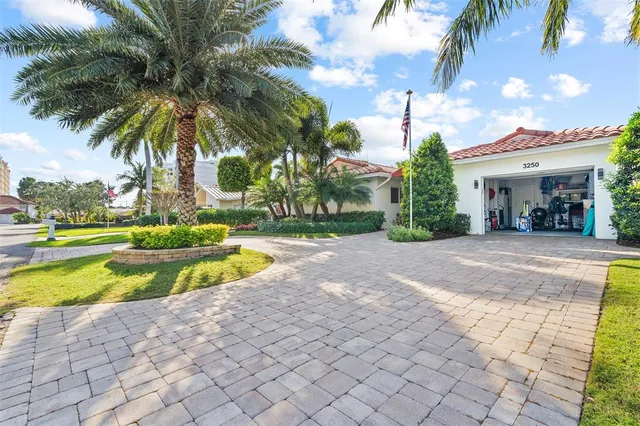 a view of a swimming pool with a yard and palm trees