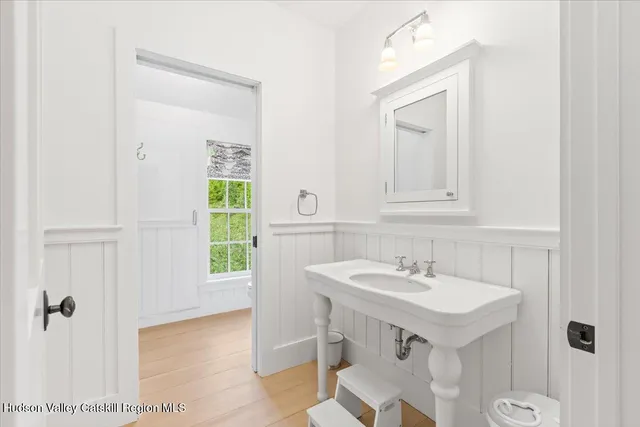 a bathroom with a sink a toilet and a mirror