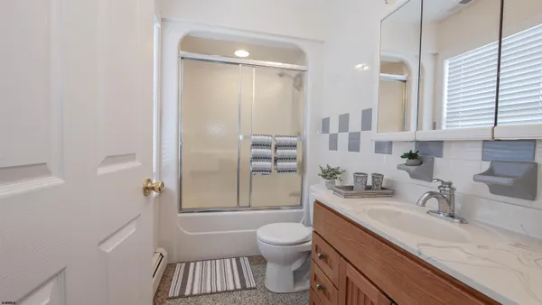 a bathroom with a granite countertop sink toilet a shower and a mirror