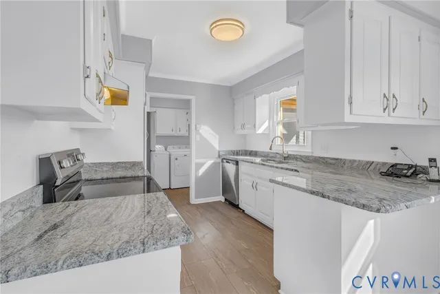a kitchen with stainless steel appliances granite countertop a refrigerator stove and white cabinets