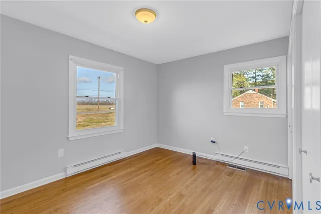 a view of an empty room with wooden floor