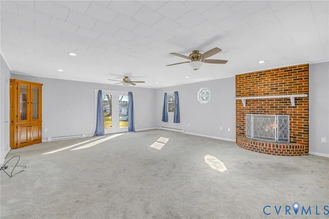 a view of an empty room with a fireplace and a window