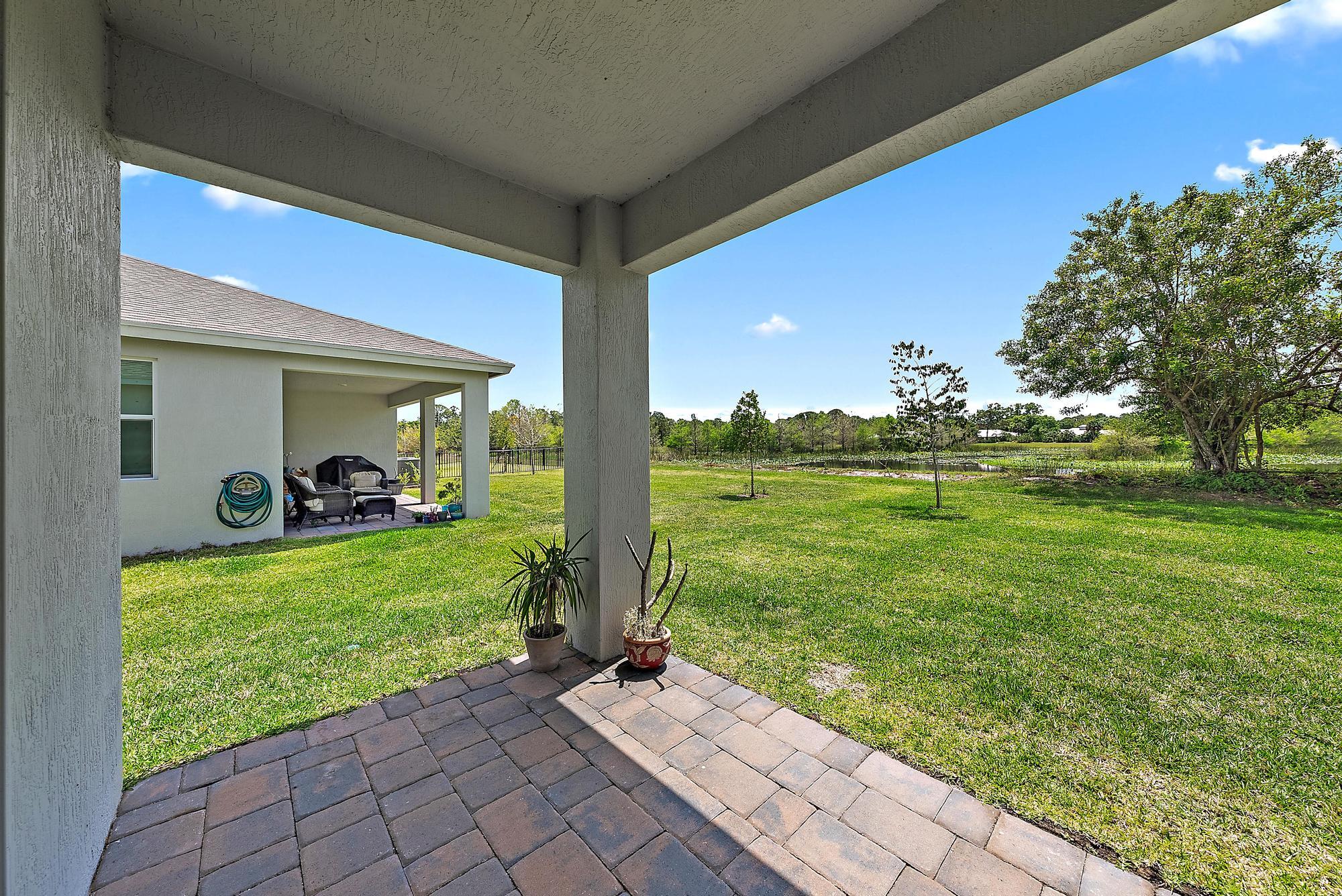 5880 Southeast Sky Blue Circle Stuart, FL 34997 - Photo 30 of 48 a front view of a house with a yard