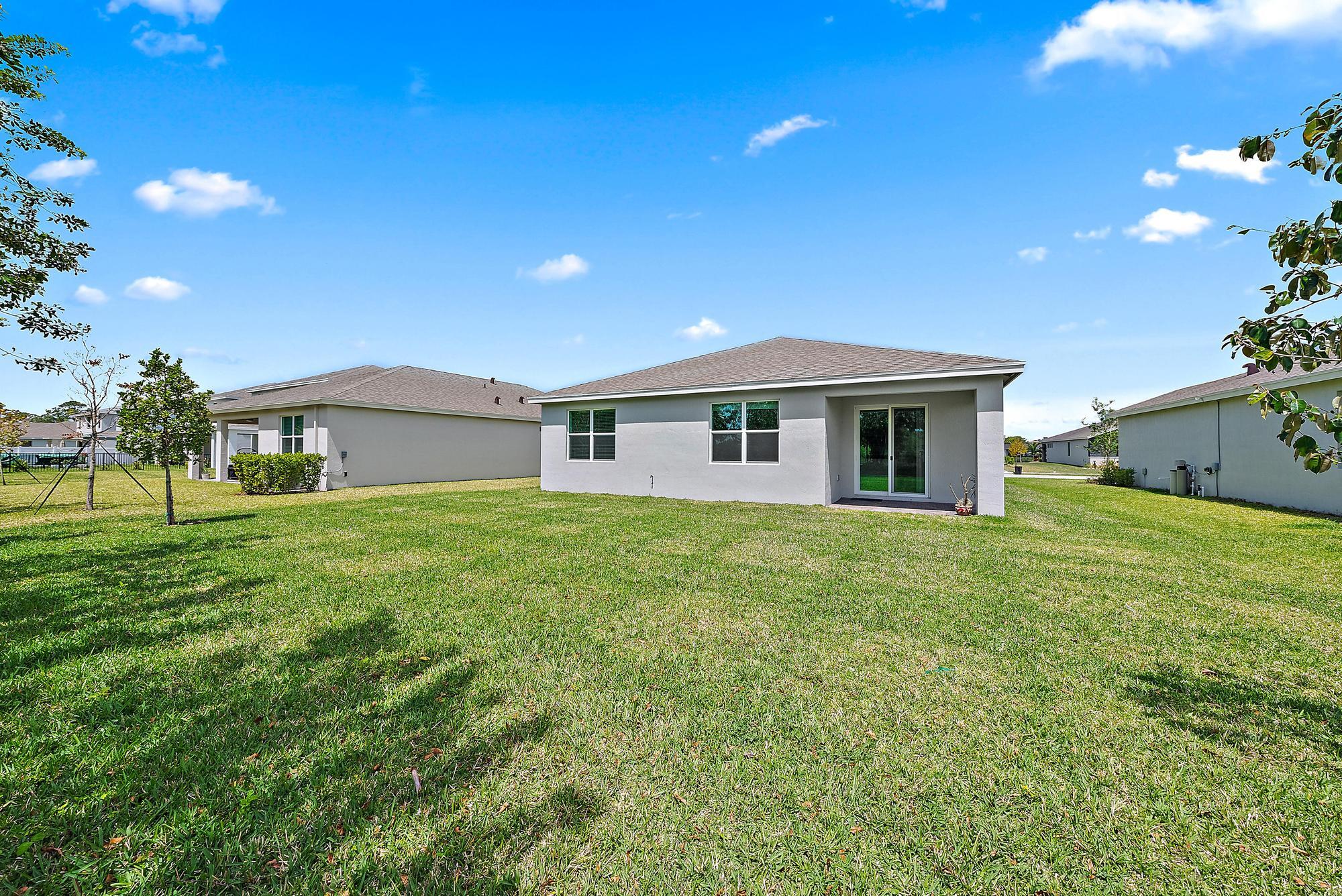 5880 Southeast Sky Blue Circle Stuart, FL 34997 - Photo 32 of 48 a front view of a house with a yard