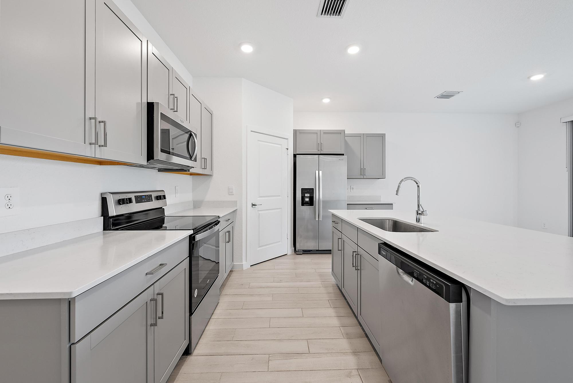 5880 Southeast Sky Blue Circle Stuart, FL 34997 - Photo 4 of 48 a kitchen with stainless steel appliances a sink dishwasher stove top oven and refrigerator