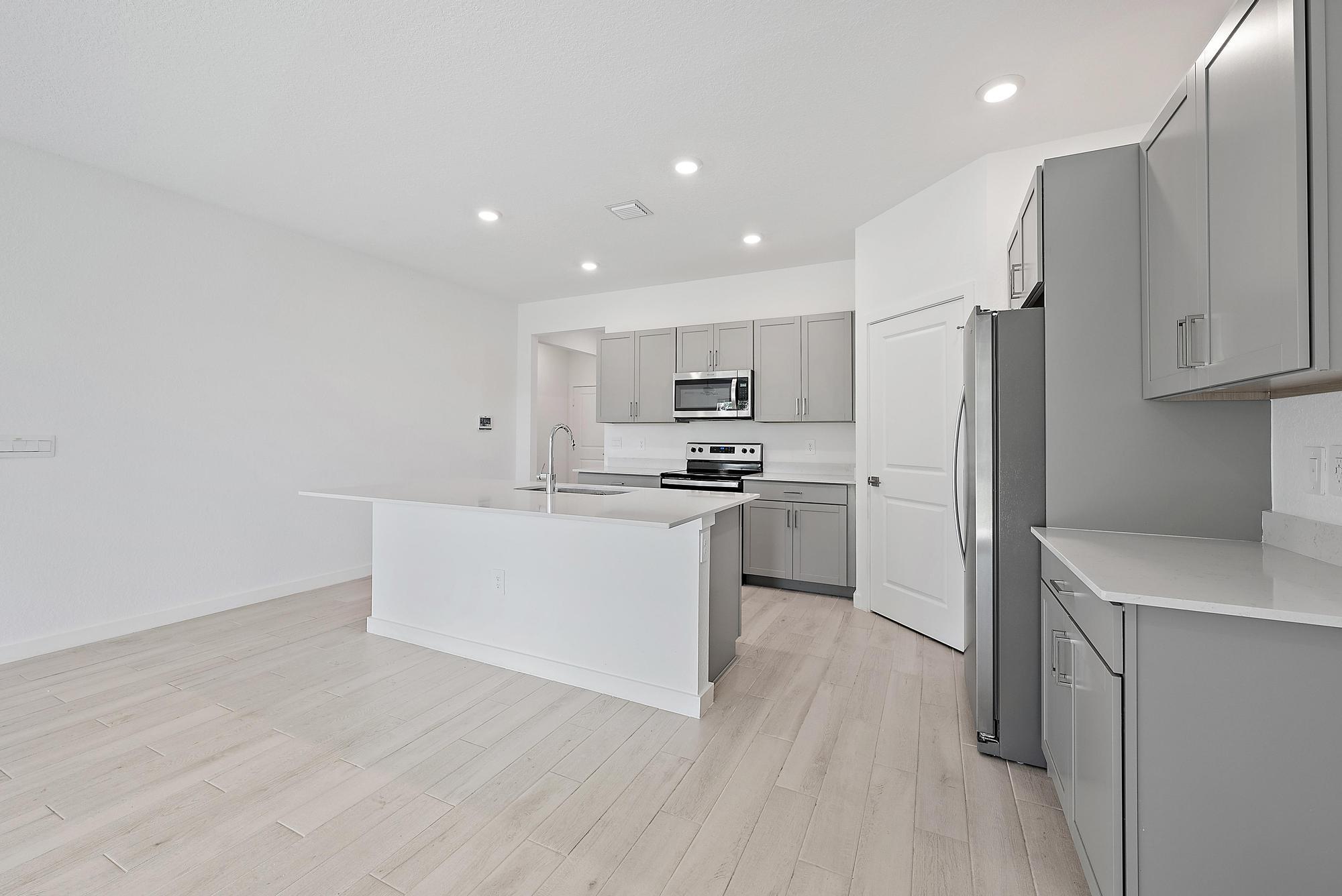 5880 Southeast Sky Blue Circle Stuart, FL 34997 - Photo 7 of 48 a kitchen with white cabinets and stainless steel appliances