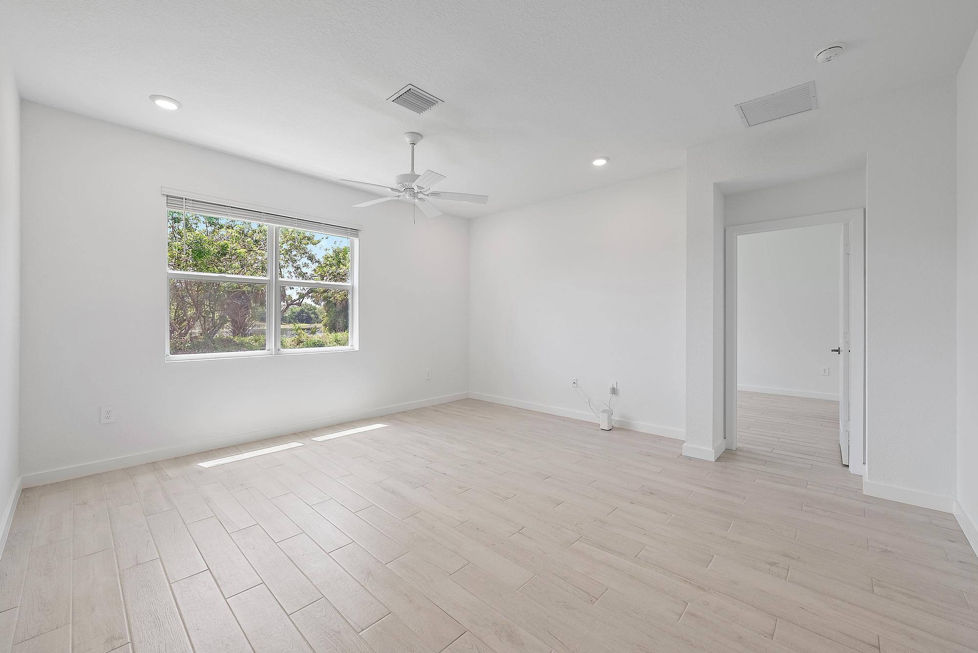 5880 Southeast Sky Blue Circle Stuart, FL 34997 - Photo 10 of 48 an empty room with wooden floor chandelier and windows