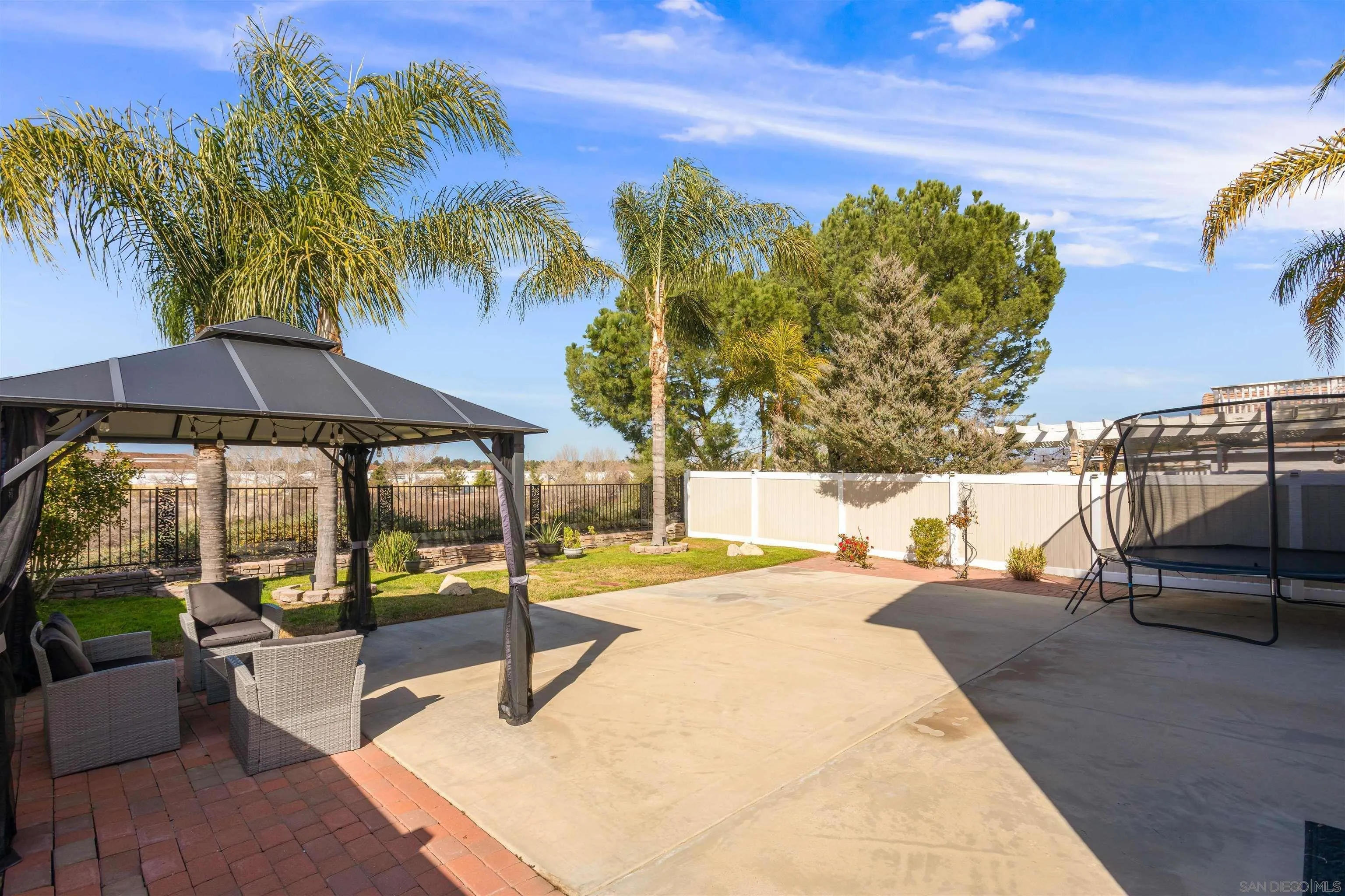 32812 Tulley Ranch Road Temecula, CA 92592 - Photo 17 of 27 a backyard of a house with table and chairs under an umbrella