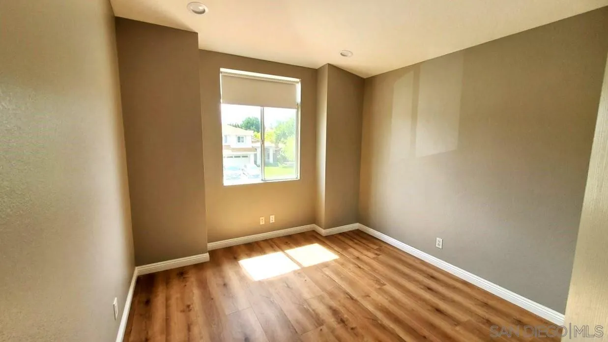 32812 Tulley Ranch Road Temecula, CA 92592 - Photo 10 of 27 an empty room with wooden floor and windows