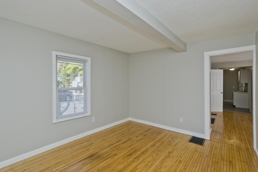 293 Eastern Avenue Springfield, MA 01109 - Photo 13 of 31 a view of empty room with wooden floor and fan