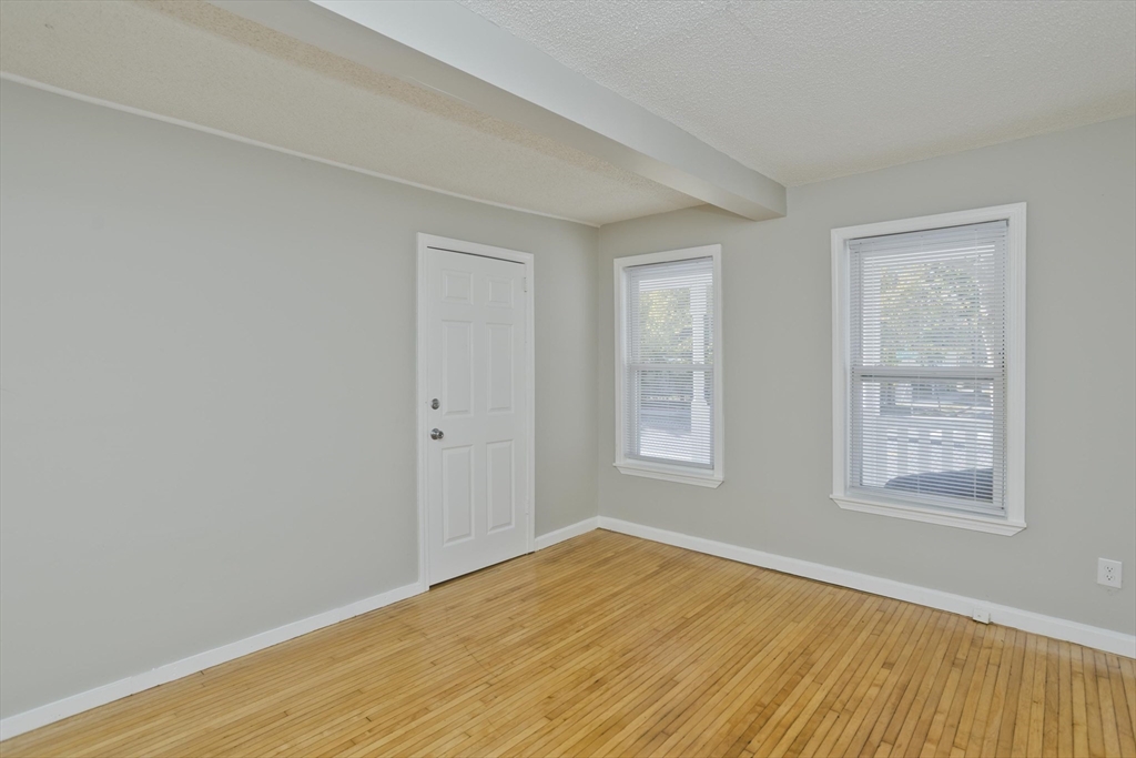 293 Eastern Avenue Springfield, MA 01109 - Photo 15 of 31 an empty room with wooden floor and windows