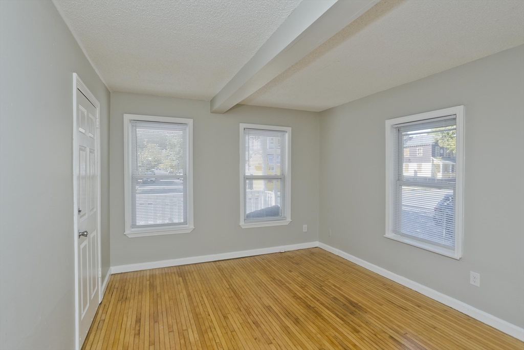 293 Eastern Avenue Springfield, MA 01109 - Photo 16 of 31 a view of an empty room with wooden floor and a window
