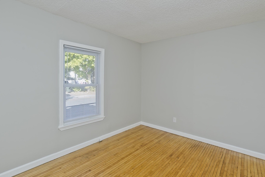 293 Eastern Avenue Springfield, MA 01109 - Photo 18 of 31 an empty room with wooden floor and windows