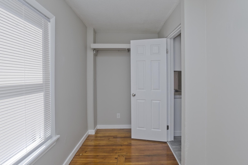 293 Eastern Avenue Springfield, MA 01109 - Photo 26 of 31 a view of a hallway with wooden floor and a bathroom