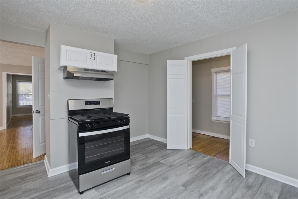 293 Eastern Avenue Springfield, MA 01109 - Photo 3 of 31 a kitchen with wooden floor and a stove