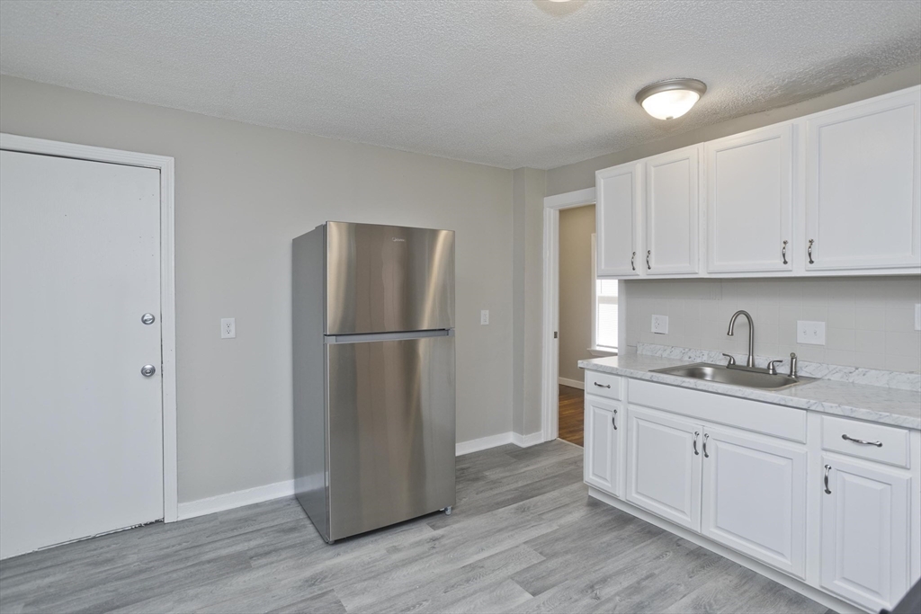 293 Eastern Avenue Springfield, MA 01109 - Photo 7 of 31 a kitchen with a refrigerator sink and cabinets