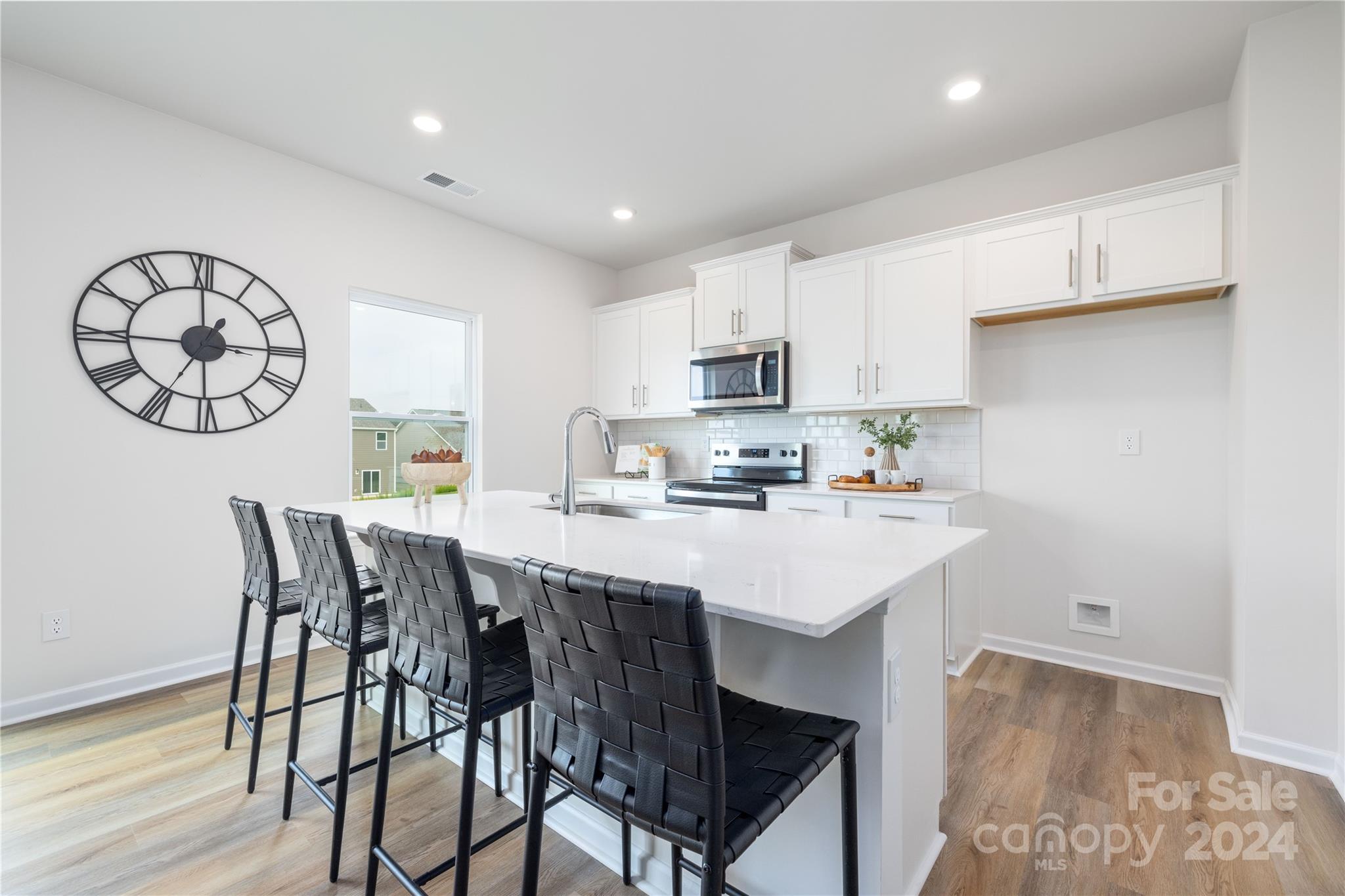 7910 Old Brk Road Sherrills Ford, NC 28673 - Photo 9 of 24 a kitchen with stainless steel appliances a table chairs and a refrigerator