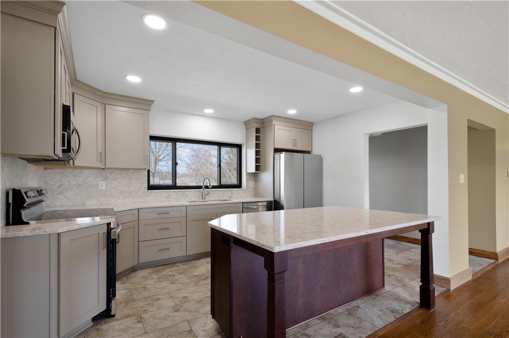 330 Center Grange Road Monaca, PA 15061 - Photo 4 of 26 a kitchen with kitchen island sink refrigerator and white cabinets