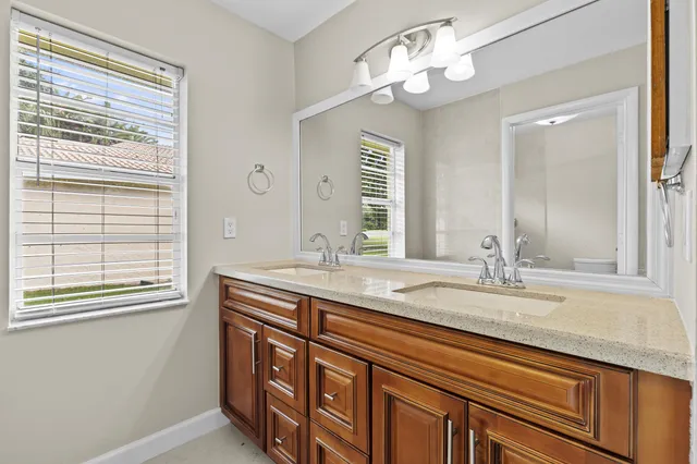 a bathroom with a granite countertop sink a large mirror and a window