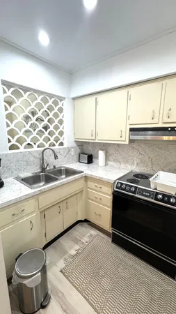 a kitchen with stainless steel appliances a sink a stove a refrigerator and cabinets