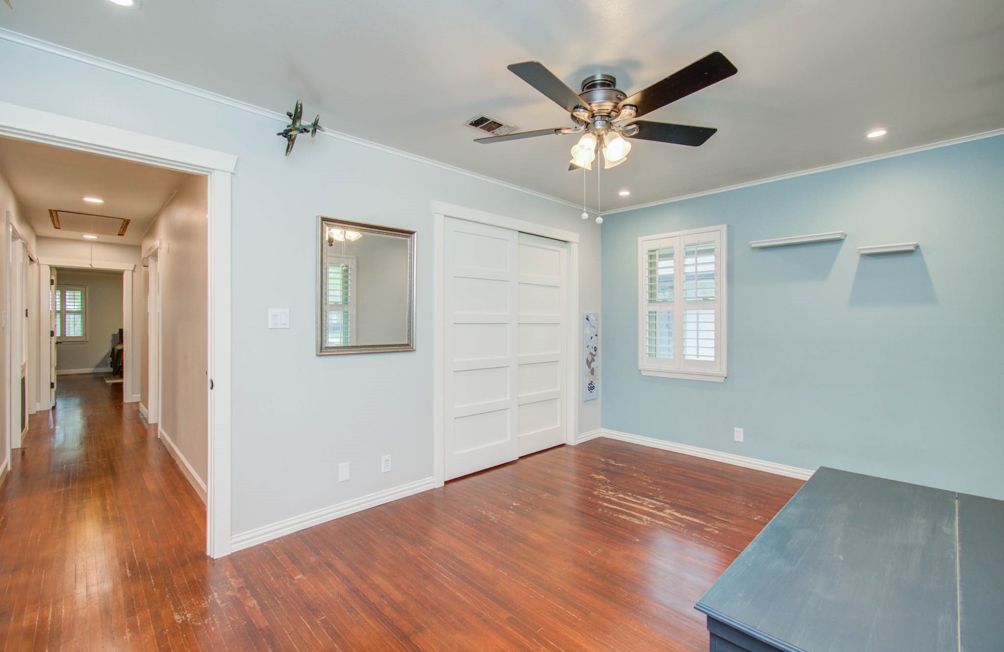 9002 Railton Street Houston, TX 77080 - Photo 19 of 32 a view of an empty room with wooden floor and a ceiling fan