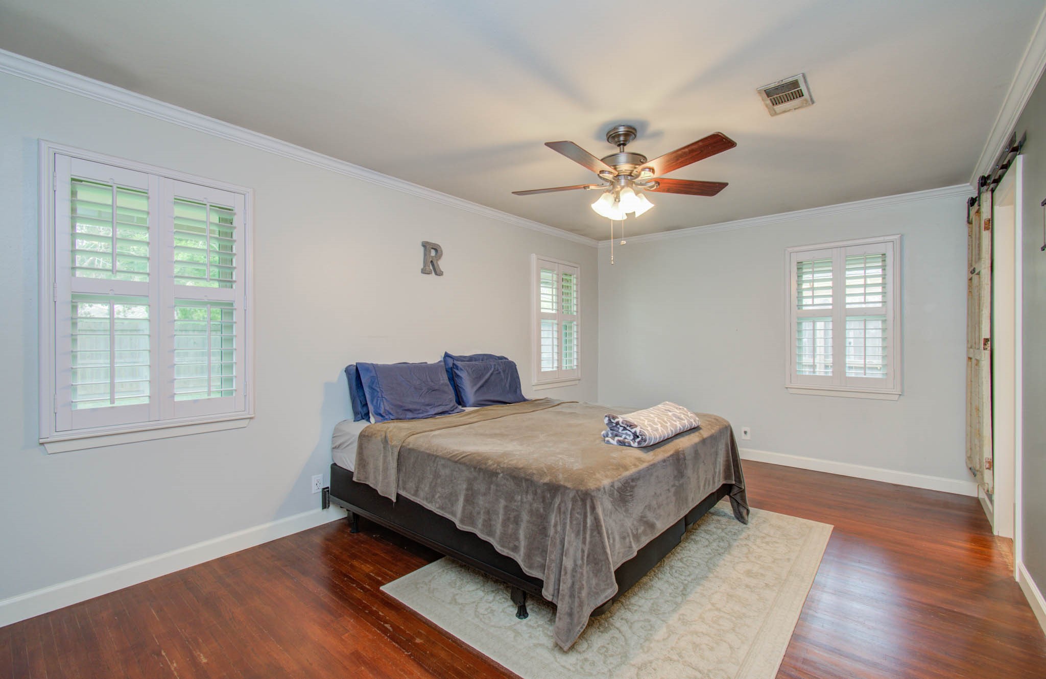 9002 Railton Street Houston, TX 77080 - Photo 24 of 32 a bedroom with a large bed chandelier and a window