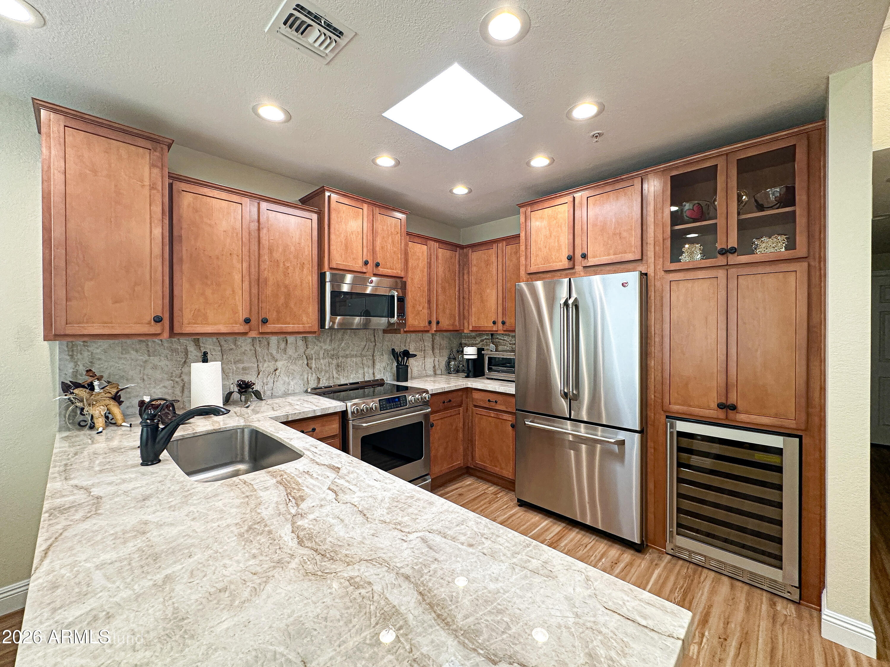 7222 East Gainey Ranch Road, Unit 224 Scottsdale, AZ 85258 - Photo 6 of 42 a kitchen with stainless steel appliances granite countertop a refrigerator sink and cabinets