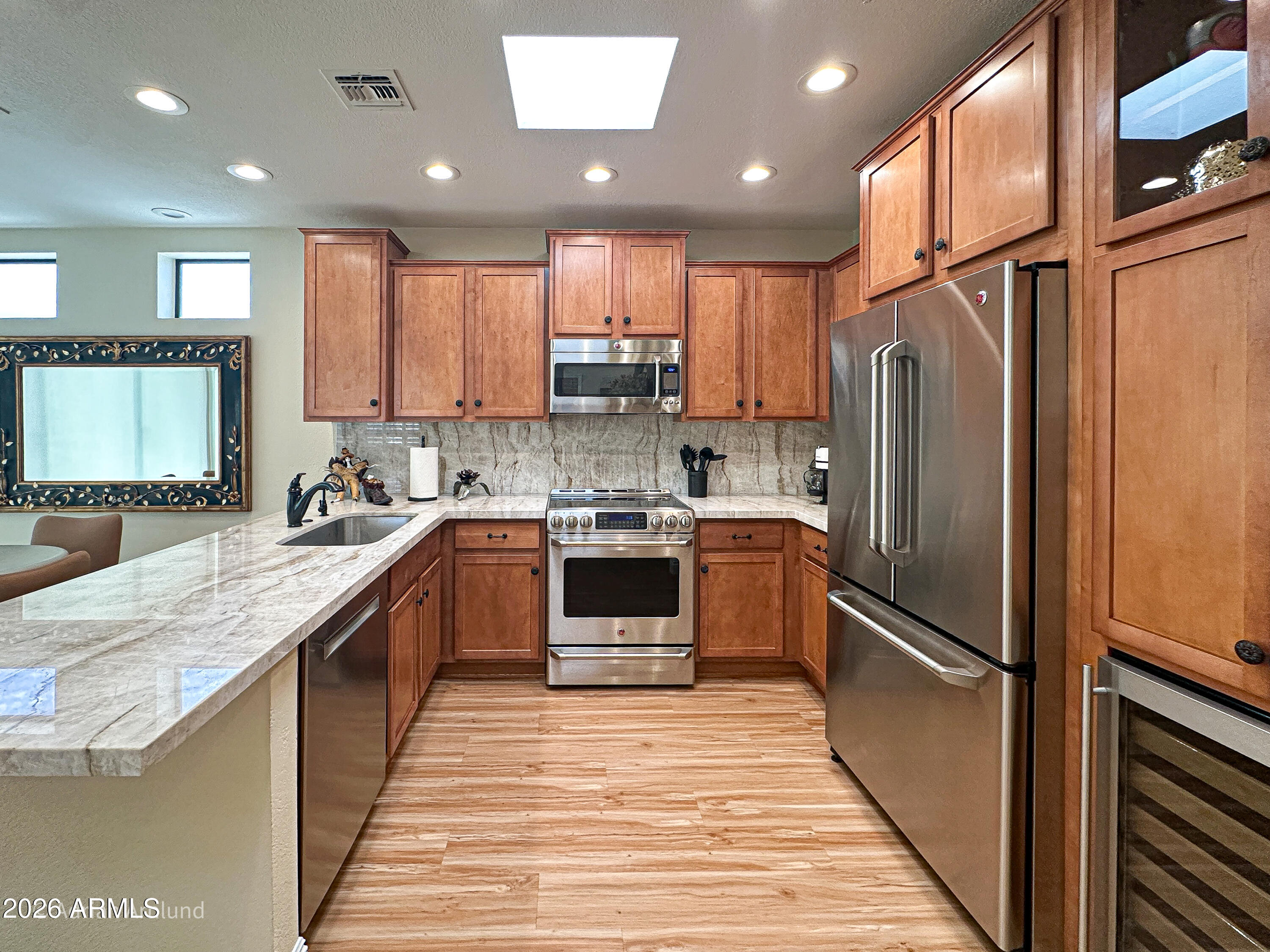 7222 East Gainey Ranch Road, Unit 224 Scottsdale, AZ 85258 - Photo 8 of 42 a kitchen with kitchen island granite countertop stainless steel appliances cabinets a sink and a center island