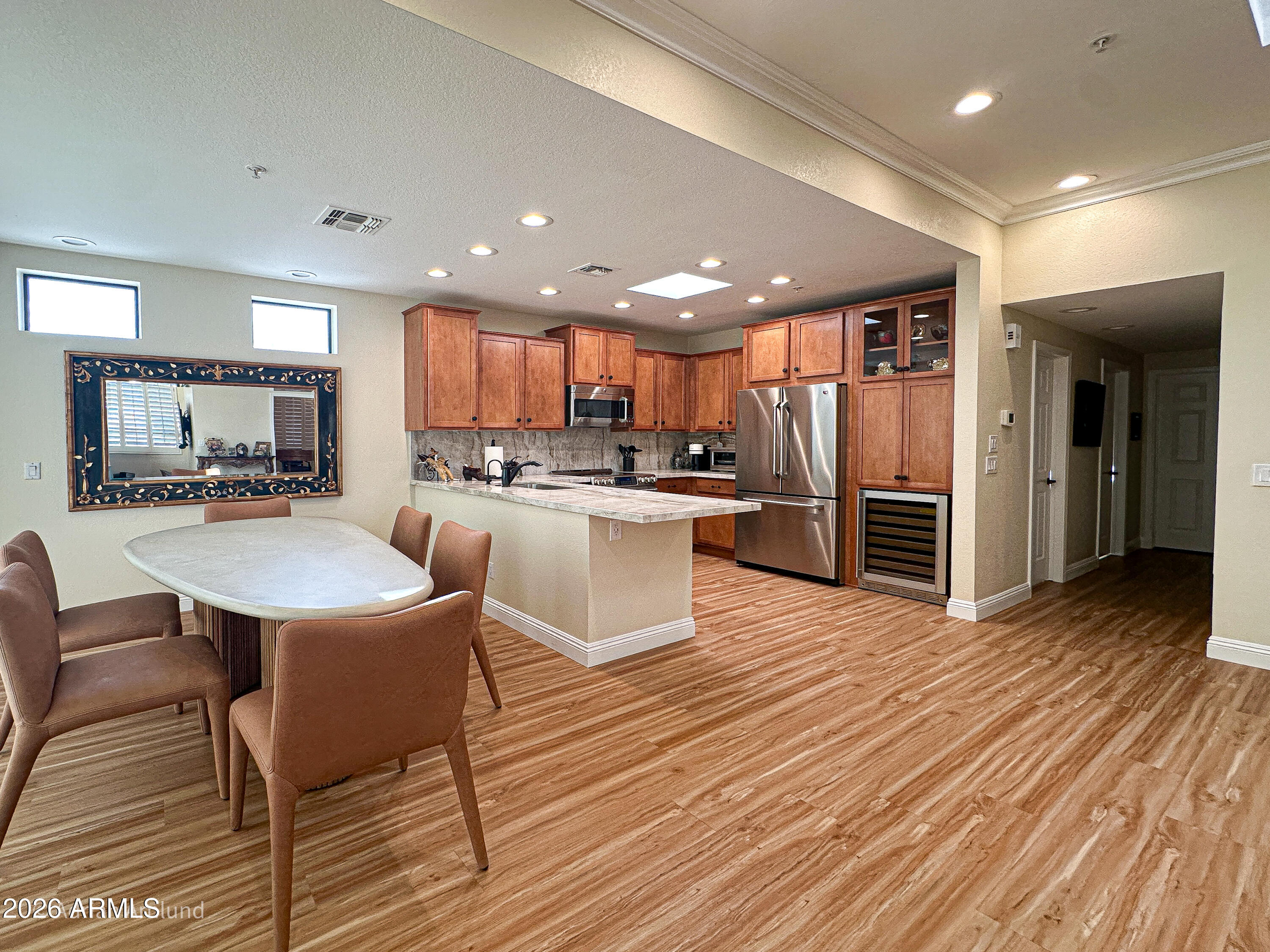 7222 East Gainey Ranch Road, Unit 224 Scottsdale, AZ 85258 - Photo 9 of 42 a kitchen with stainless steel appliances a dining table chairs microwave and sink