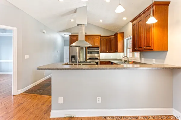 a kitchen with stainless steel appliances granite countertop a stove a sink and a refrigerator