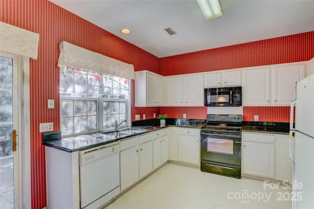 a kitchen with stainless steel appliances granite countertop a stove sink and cabinets