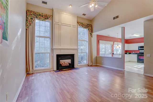 a view of a livingroom with wooden floor and a fireplace