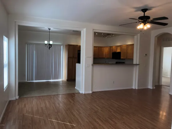 a view of a livingroom with wooden floor and a ceiling fan