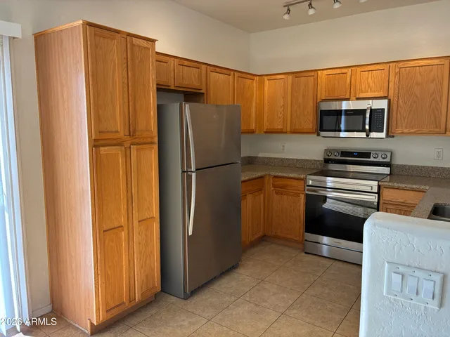 a kitchen with stainless steel appliances granite countertop a refrigerator and a stove top oven