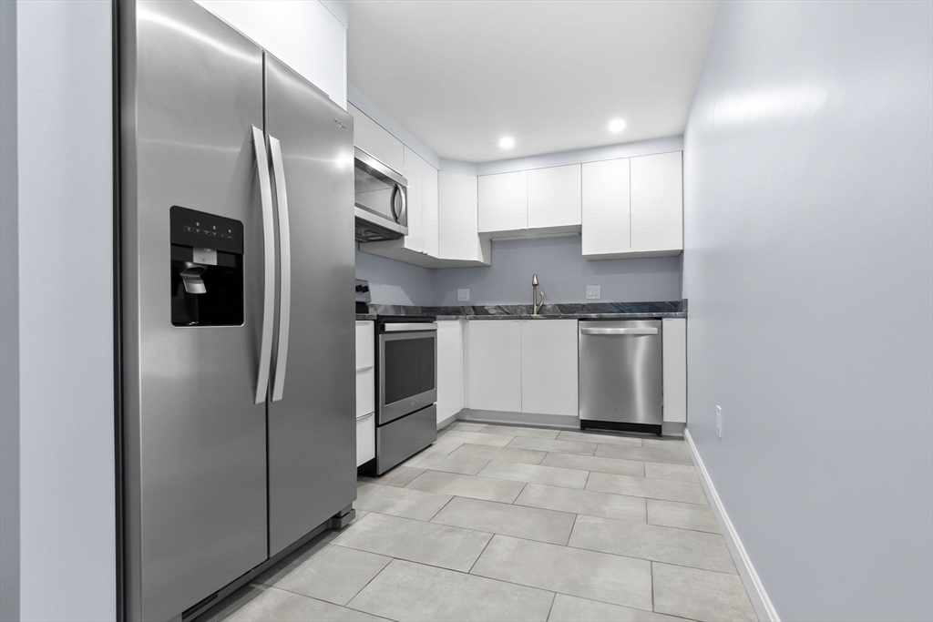 a kitchen with stainless steel appliances granite countertop a refrigerator and a sink